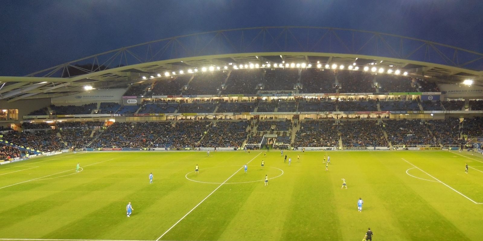 The Amex Stadium under floodlights on a match night